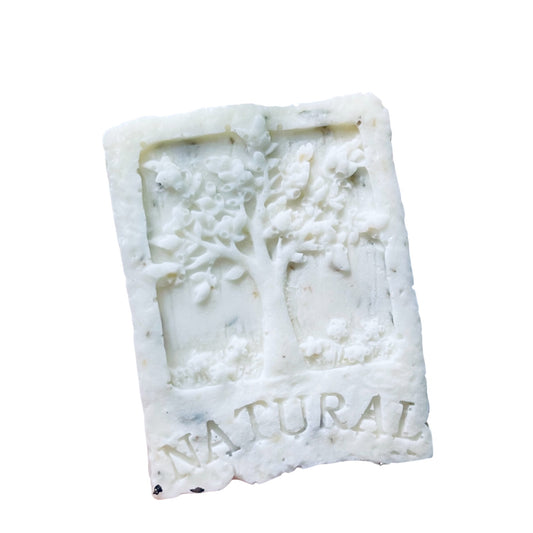 Rectangular bar of white soap with tree design and 'NATURAL' text on a white background