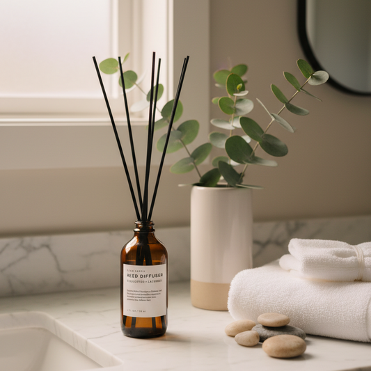 Eucalyptus Lavender reed diffuser bottle styled on a bathroom counter with a eucalyptus plant and towels