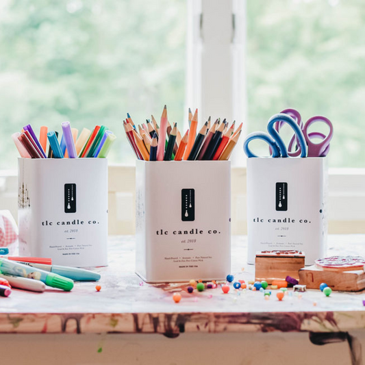 Three containers filled with stationery items on a desk with a blurred background