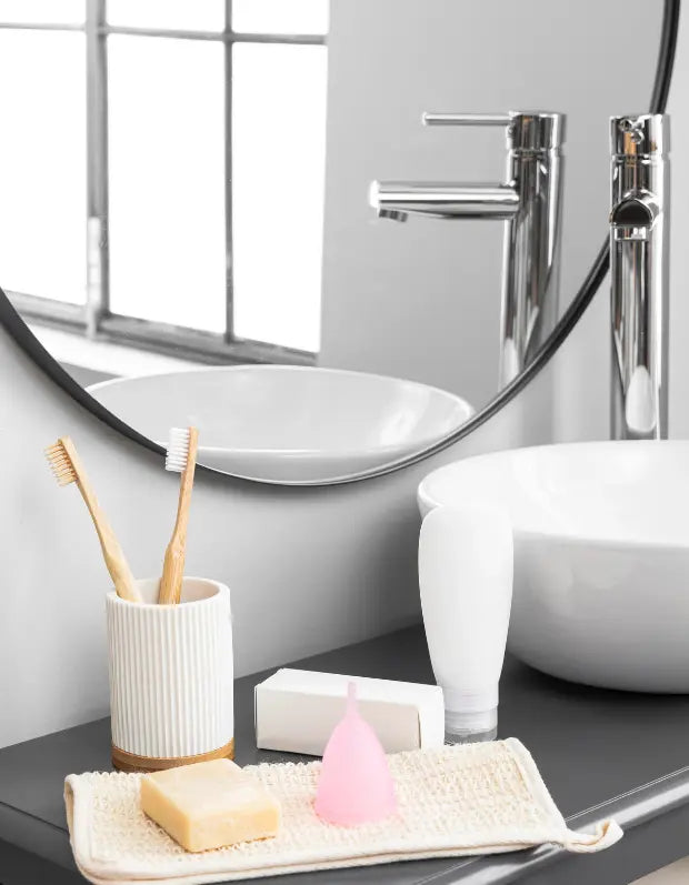 Bathroom vanity with sink, mirror, and toiletries including a toothbrush holder and soap.