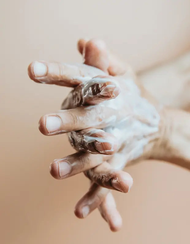 Close-up of two hands holding each other with a soft focus background