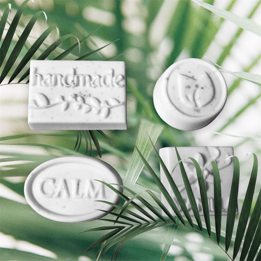 White soap bars with 'handmade' and 'calm' text on a green leaf background