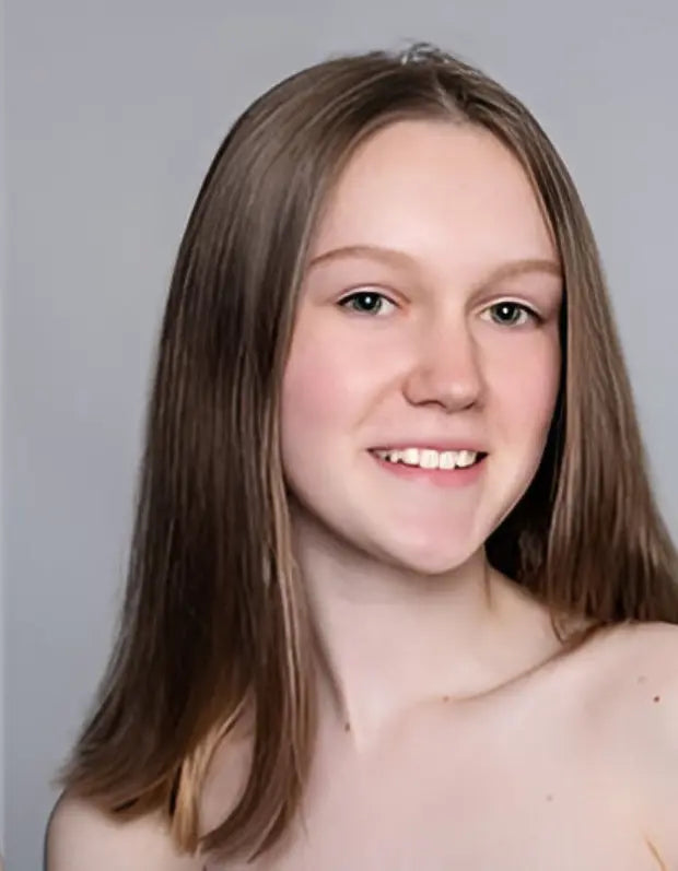 Person with long brown hair against a plain background