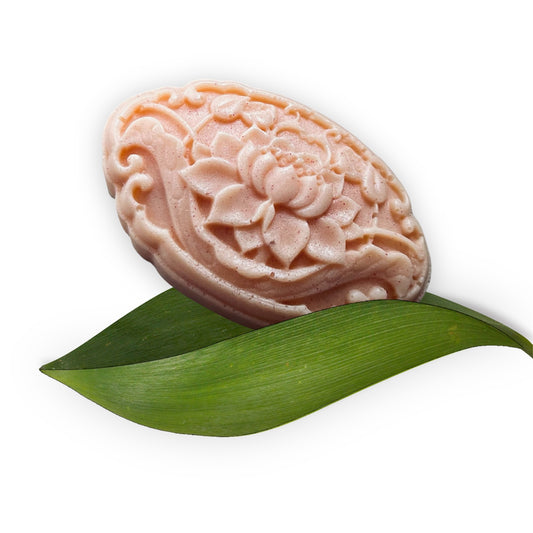 Decorative soap with floral design on a green leaf against a white background
