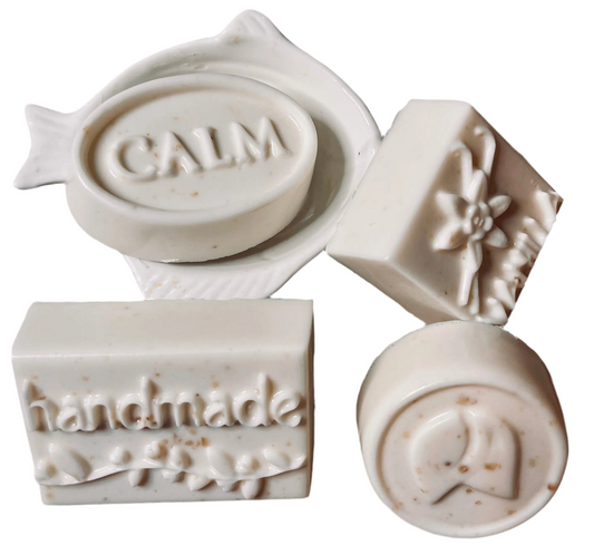 Set of handmade soap stamps with various designs on a white background