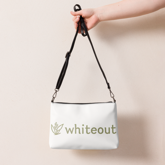 White bag with 'whiteout' logo held by a hand against a beige background