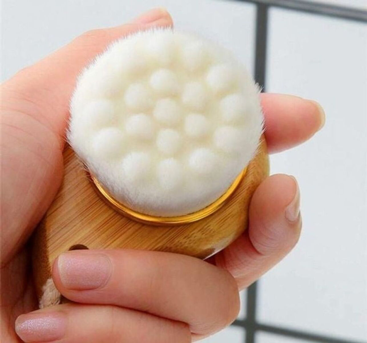 Close-up of the facial cleansing brush's soft bristle head held in a hand