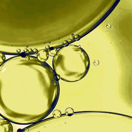 Close-up macro shot of the facial oil's texture and bubbles