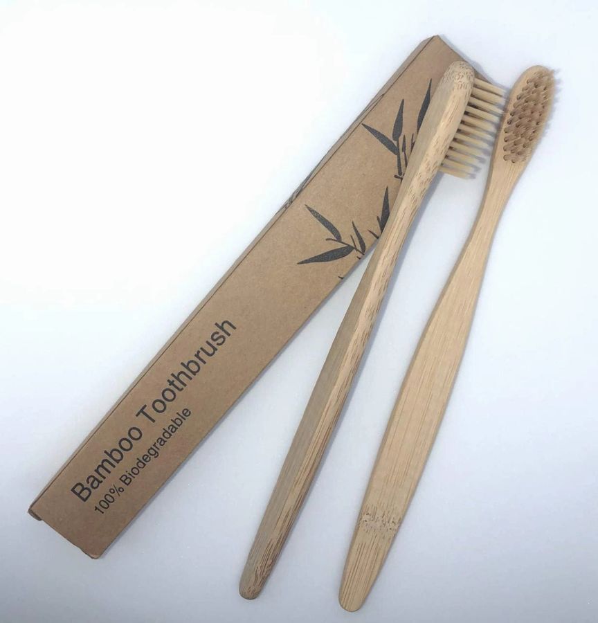 Bamboo toothbrush shown beside its biodegradable packaging